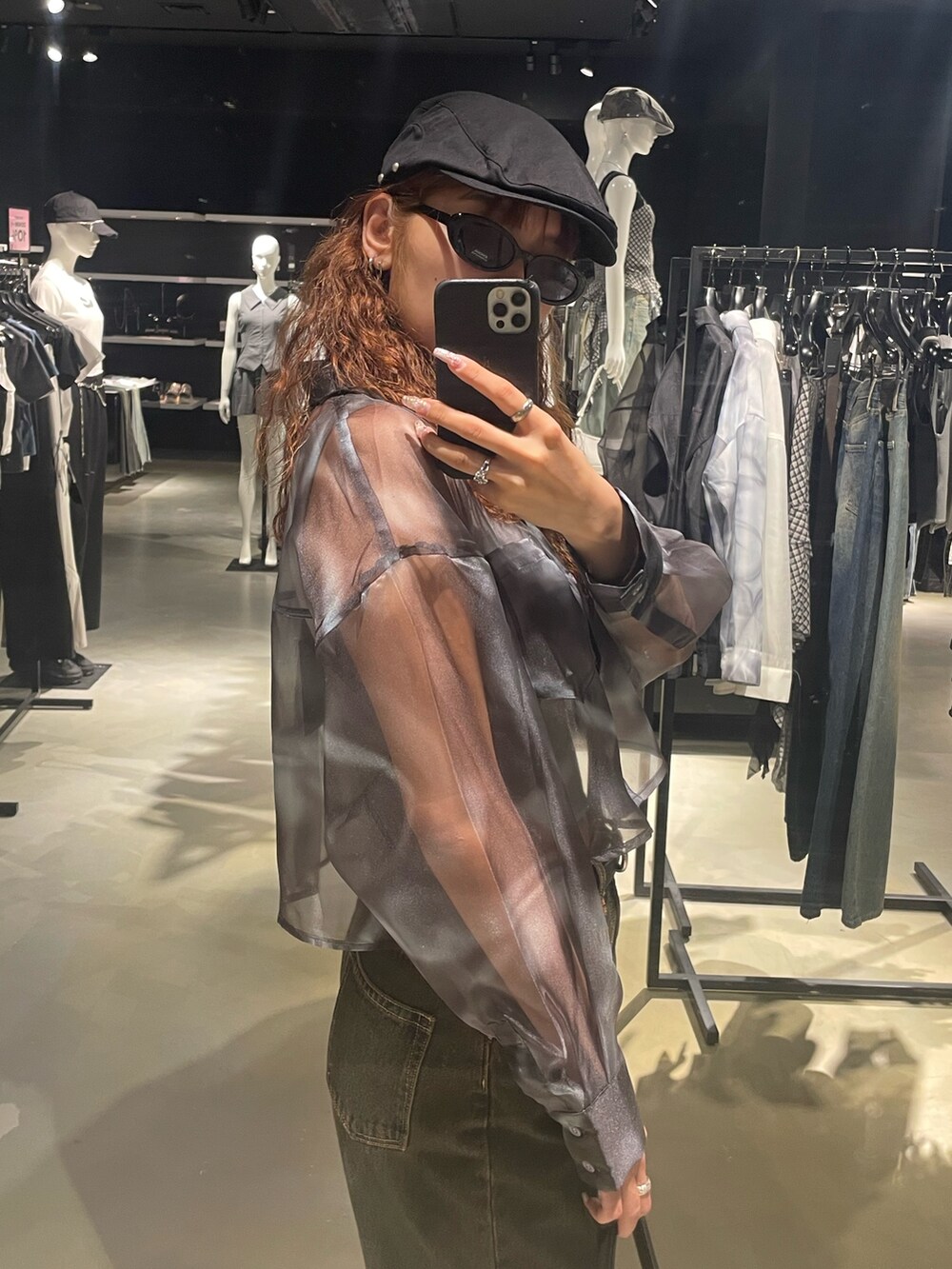 グレー系のニット/セーター、ブルー系のシャツ/ブラウス、ブルー系のデニムパンツを着用したレディースの春コーディネートの5枚目の写真