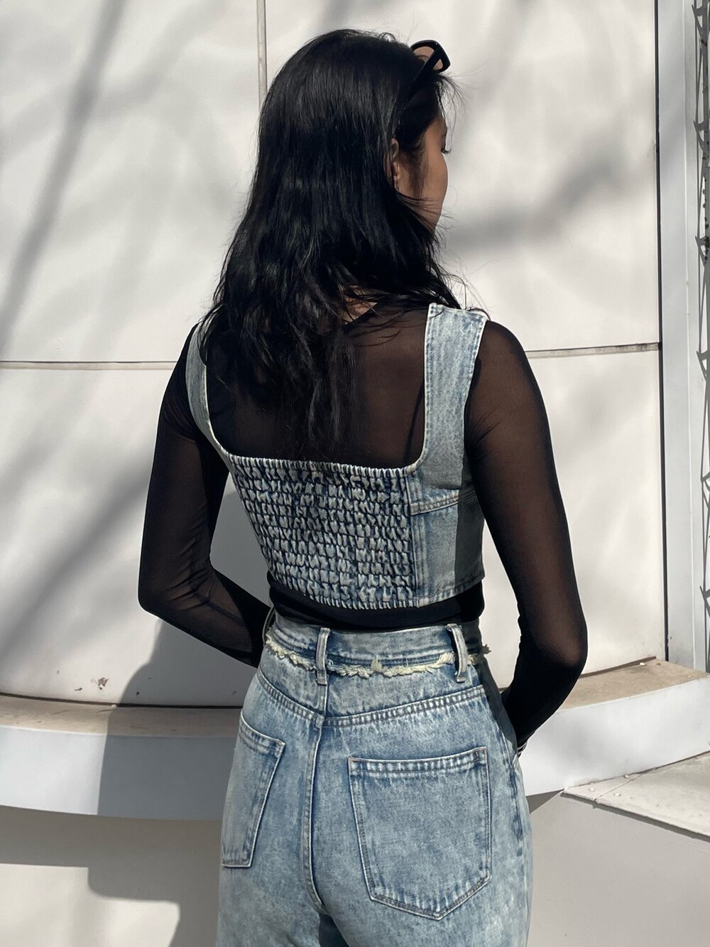 ブラック系のTシャツ/カットソー、ブルー系のキャミソール、ブルー系のデニムパンツを着用したレディースの春コーディネートの6枚目の写真