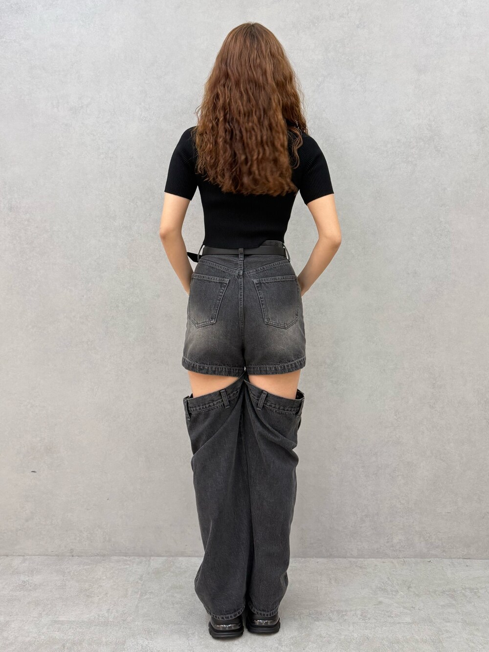 ブラック系のニット/セーター、ブラック系のデニムパンツ、ブラック系のサンダルを着用したレディースの夏コーディネートの3枚目の写真