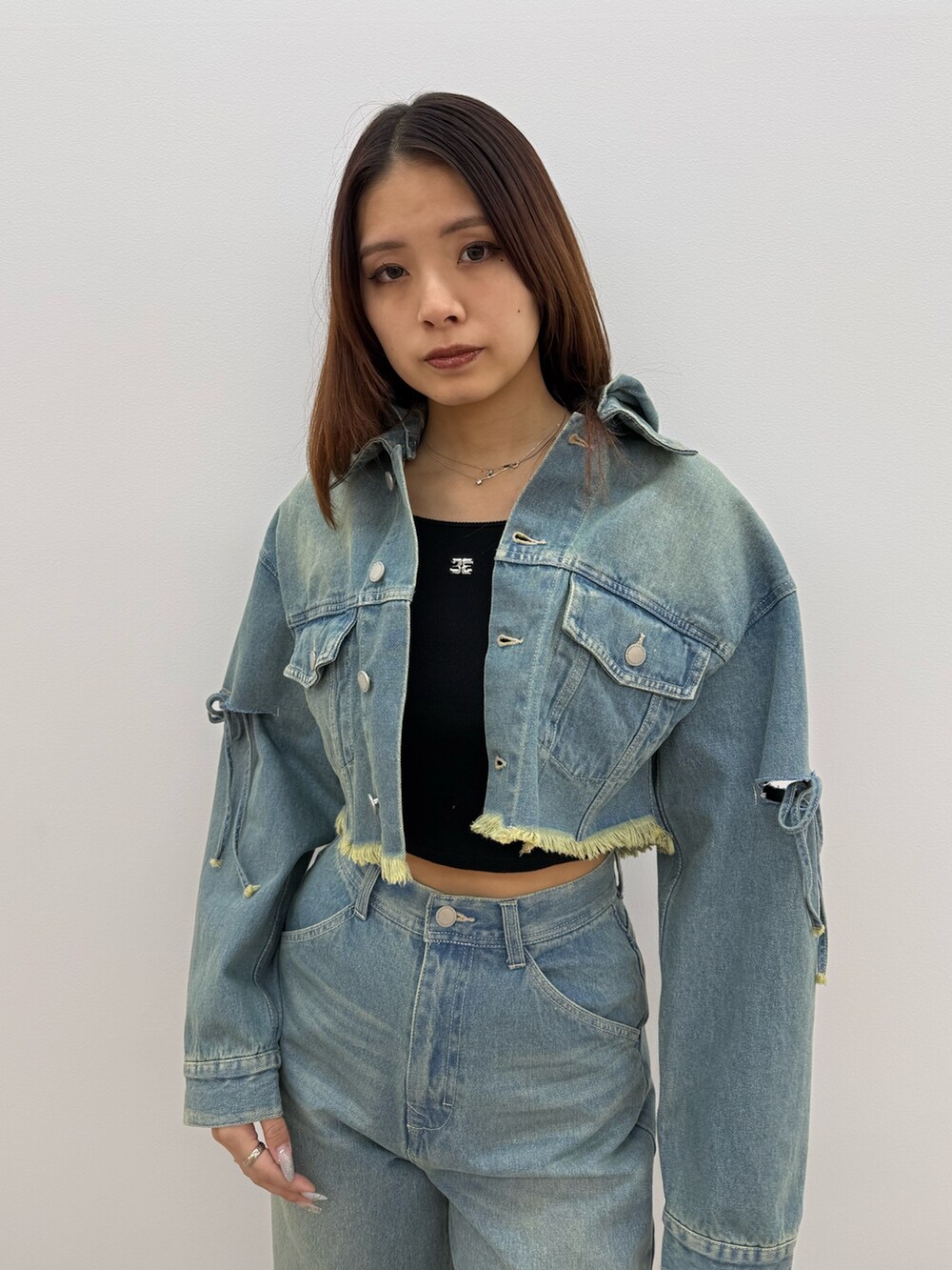 ブルー系のデニムジャケット、ブルー系のデニムパンツ、ブラック系のスニーカーを着用したレディースの冬コーディネートの4枚目の写真