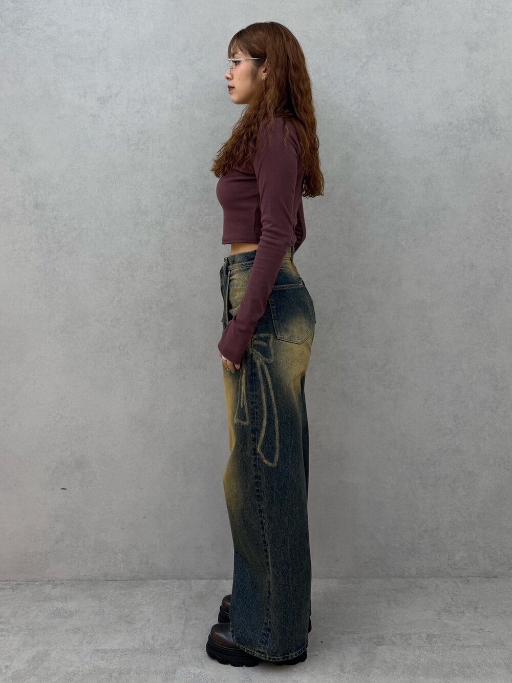 レッド系のTシャツ/カットソー、ブルー系のデニムパンツ、ブラウン系のブーツを着用したレディースの夏コーディネートの2枚目の写真