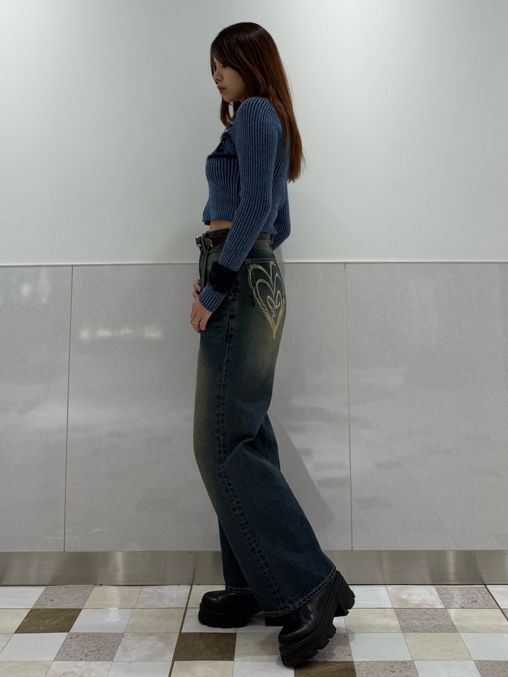 ブルー系のニット/セーター、ブルー系のデニムパンツ、ブラック系のブーツを着用したレディースの冬コーディネートの2枚目の写真