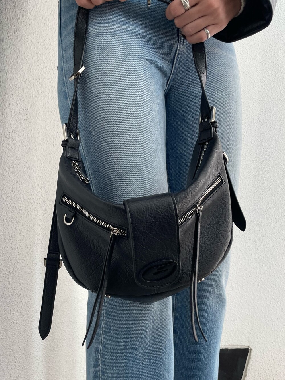 ブラック系のブルゾン、その他のニット/セーター、ブルー系のデニムパンツを着用したレディースの冬コーディネートの9枚目の写真