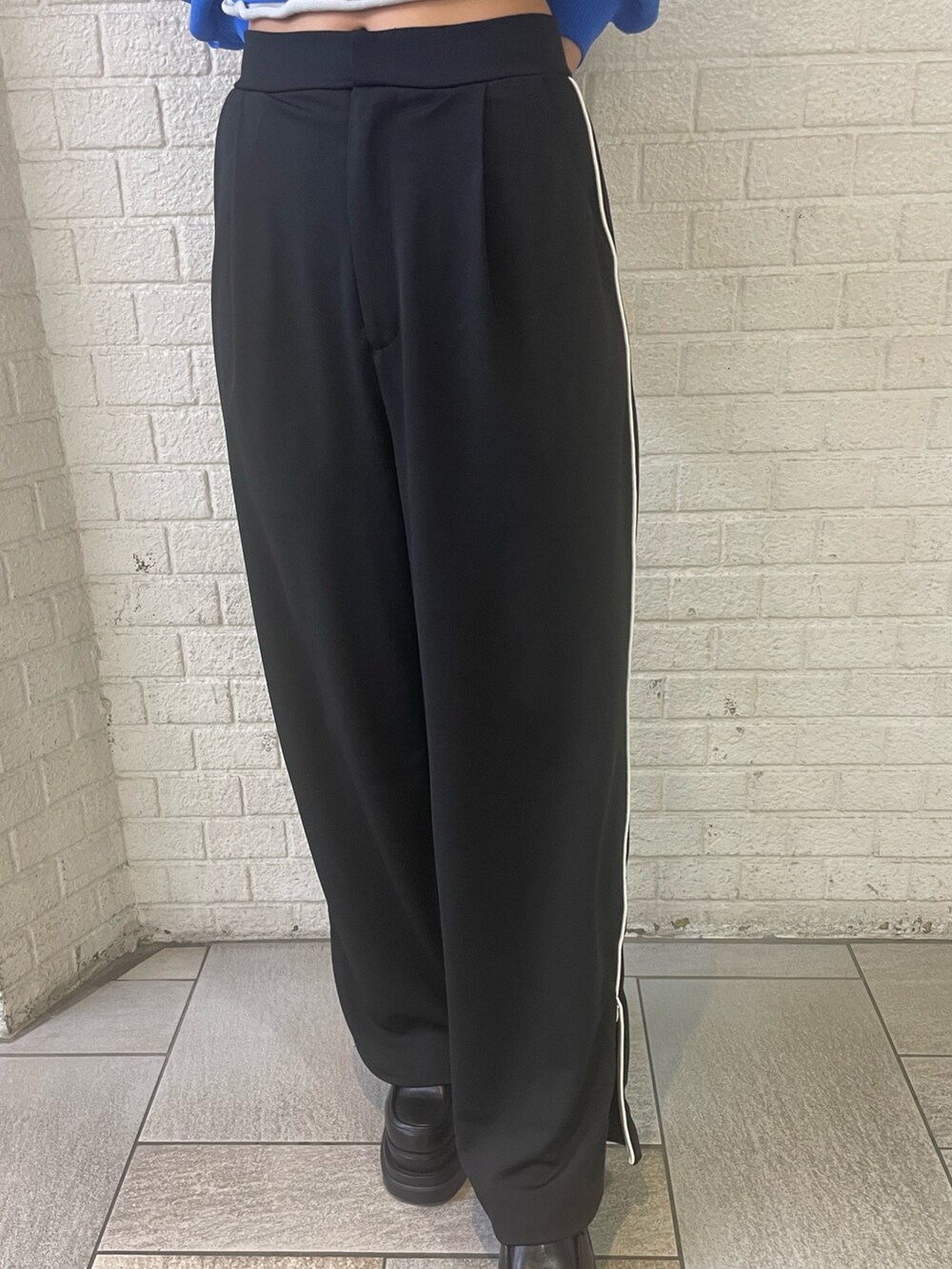 ブラック系のTシャツ/カットソー、ブラック系のスラックス、グレー系のブーツを着用したレディースの冬コーディネートの5枚目の写真