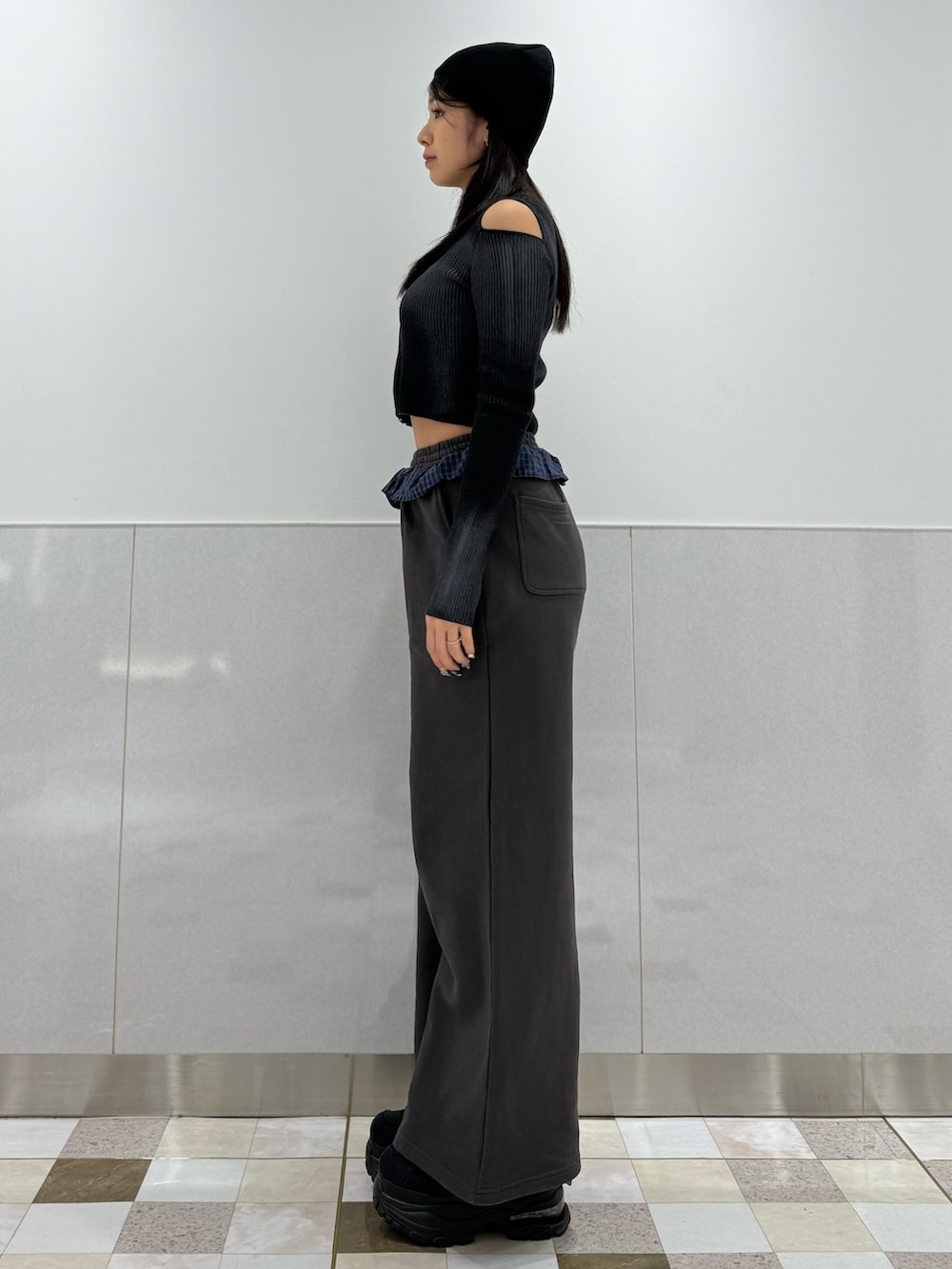 ブラック系のニット/セーター、グレー系のスウェットパンツ、ブラック系のスニーカーを着用したレディースの冬コーディネートの2枚目の写真