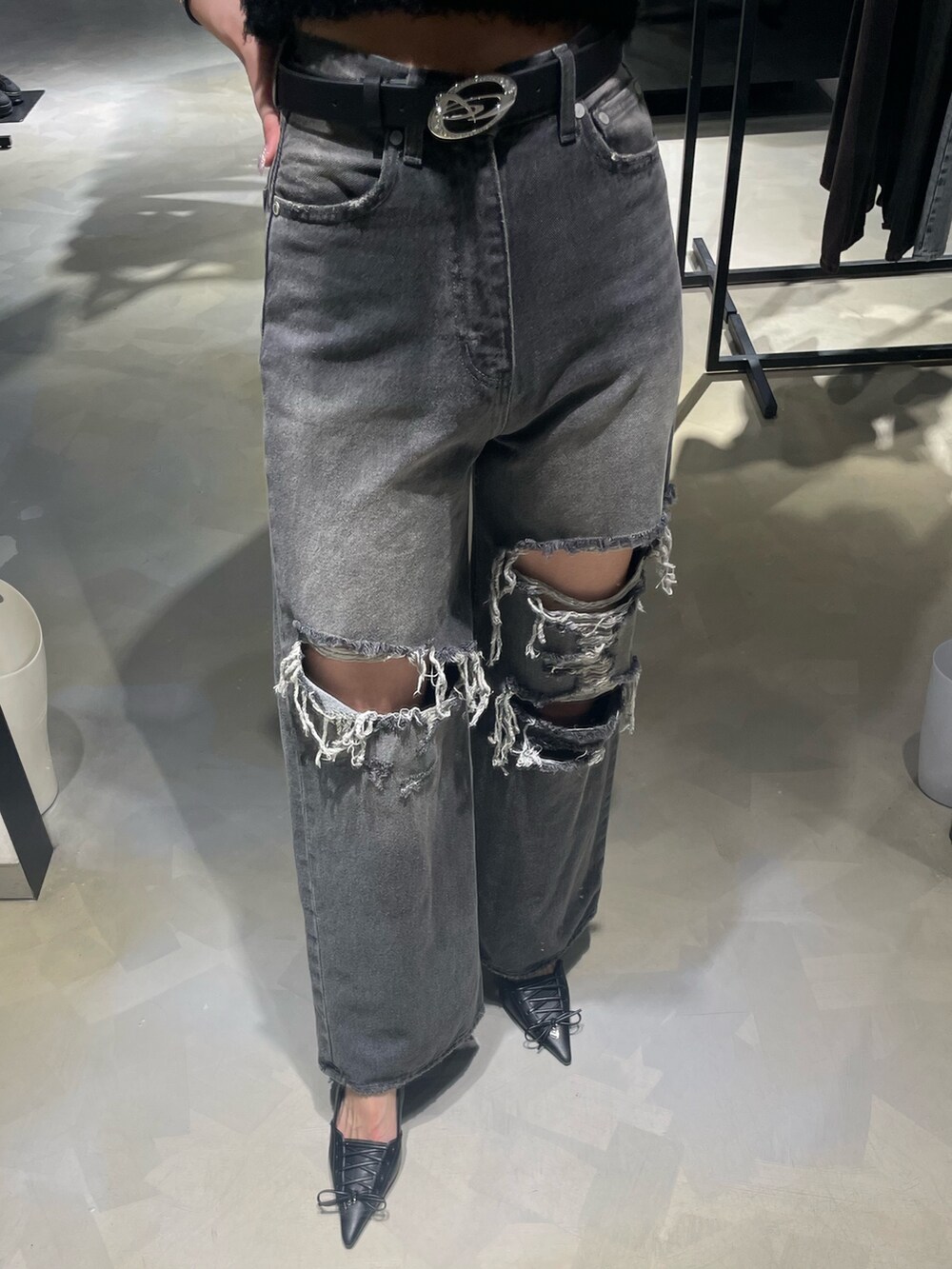 ブラック系のニット/セーター、ブラック系のデニムパンツ、ブラック系のパンプスを着用したレディースの春コーディネートの6枚目の写真