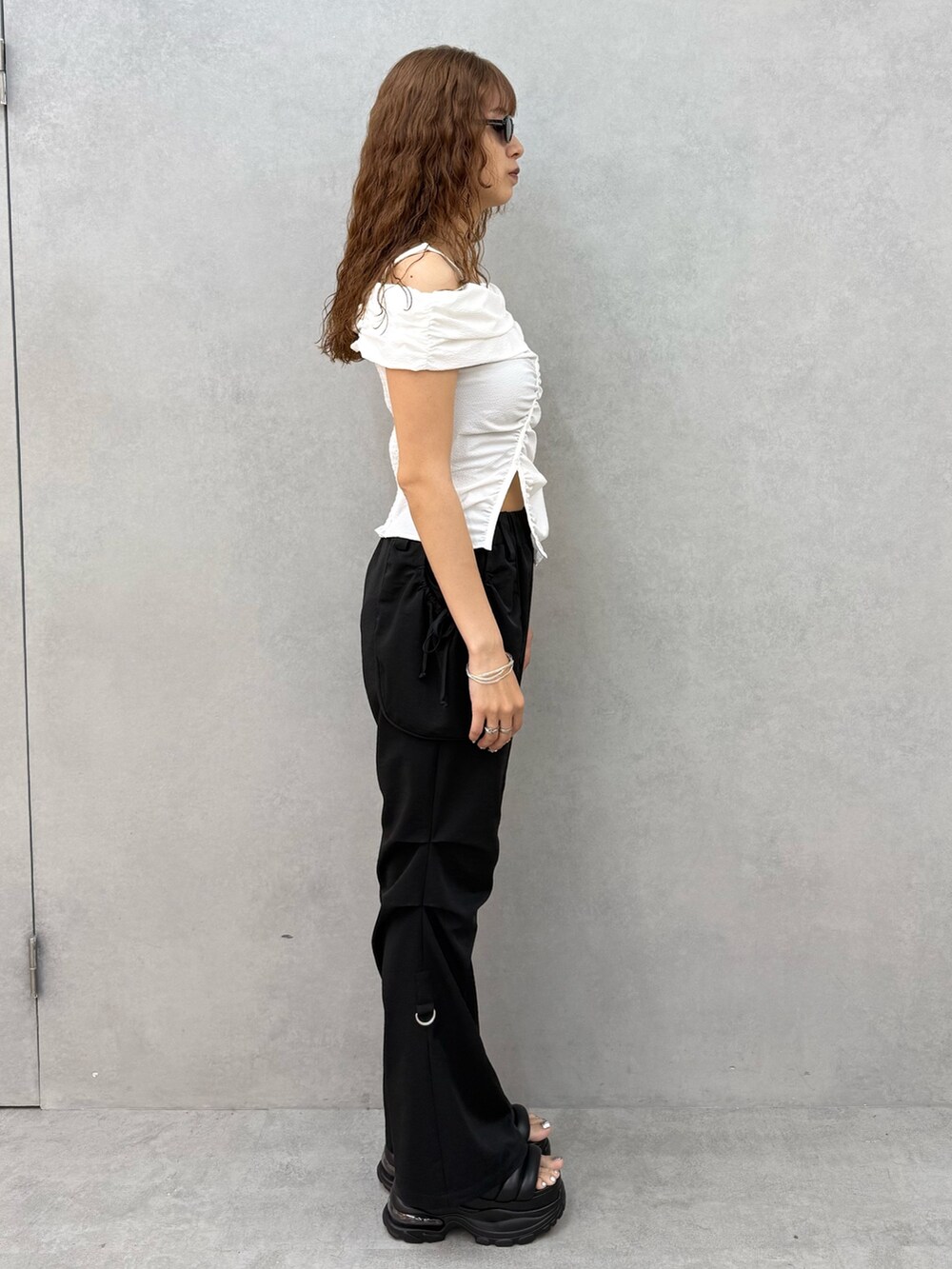 ホワイト系のTシャツ/カットソー、ブラック系のその他パンツ、ブラック系のサンダルを着用したレディースの夏コーディネートの2枚目の写真