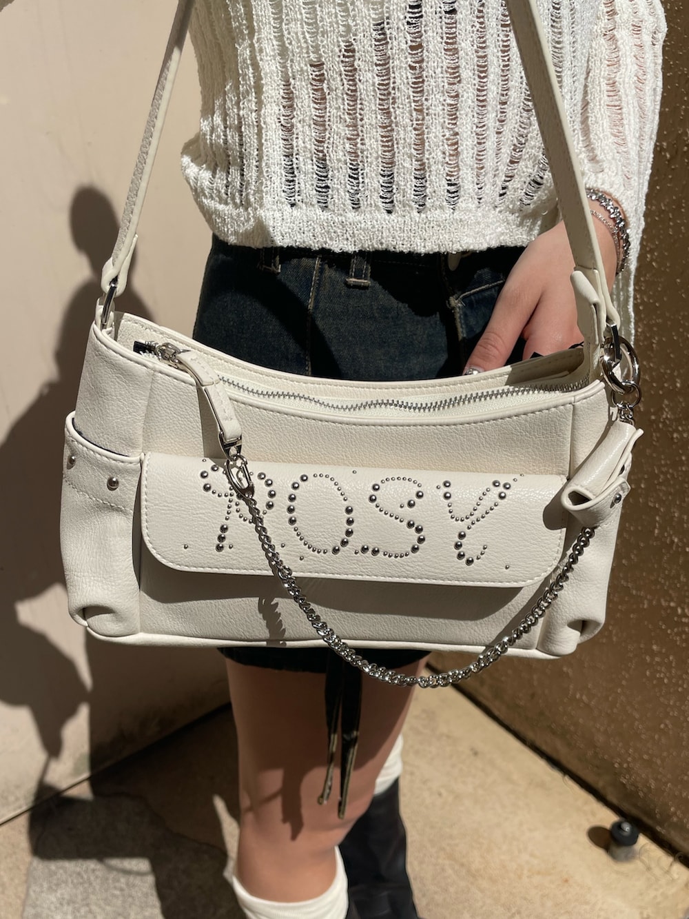 ホワイト系のニット/セーター、ブルー系のその他パンツ、ホワイト系のハンドバッグを着用したレディースの春コーディネートの9枚目の写真