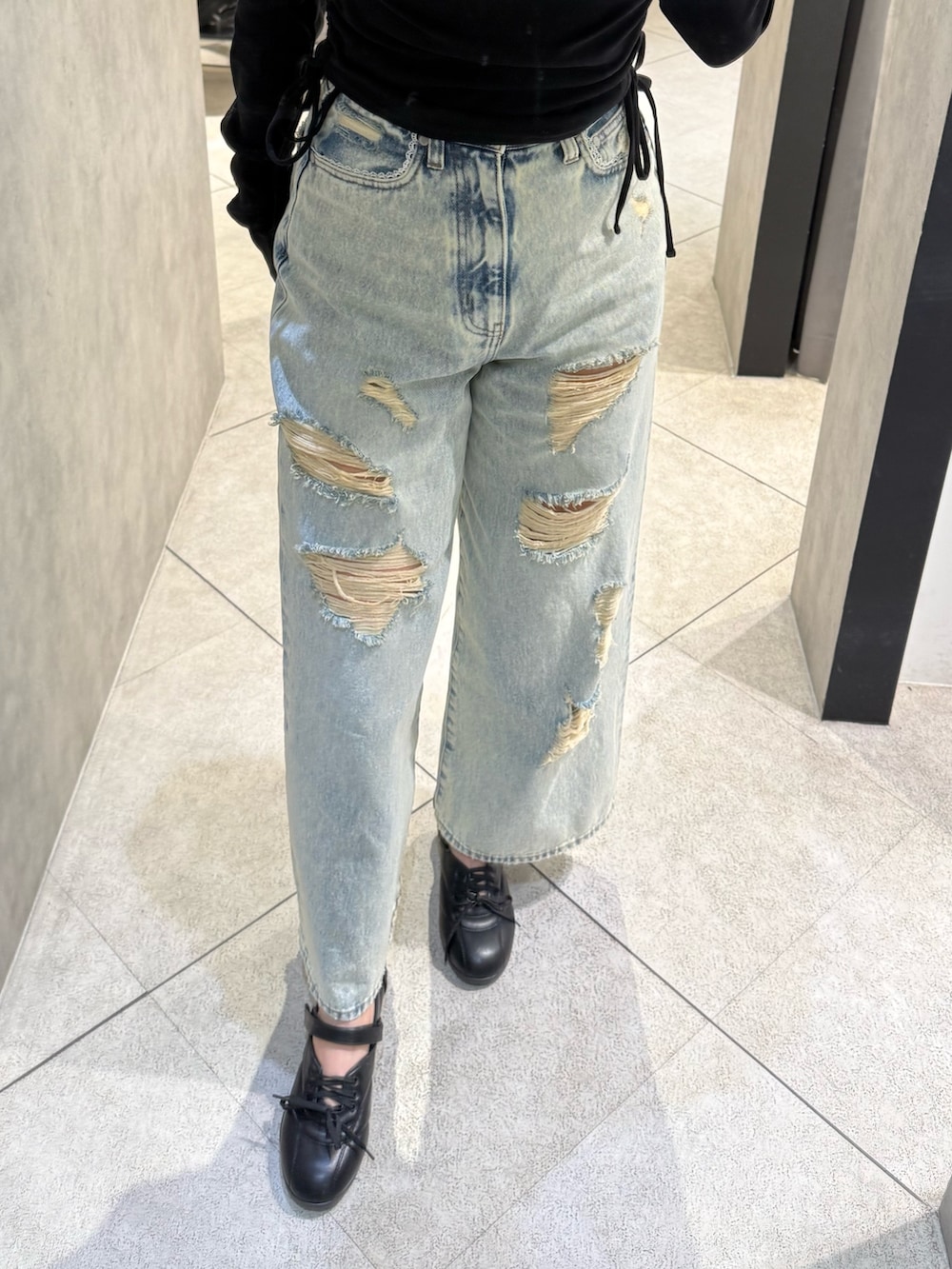 ブラック系のTシャツ/カットソー、ブルー系のデニムパンツ、ブラック系のスニーカーを着用したレディースの春コーディネートの5枚目の写真