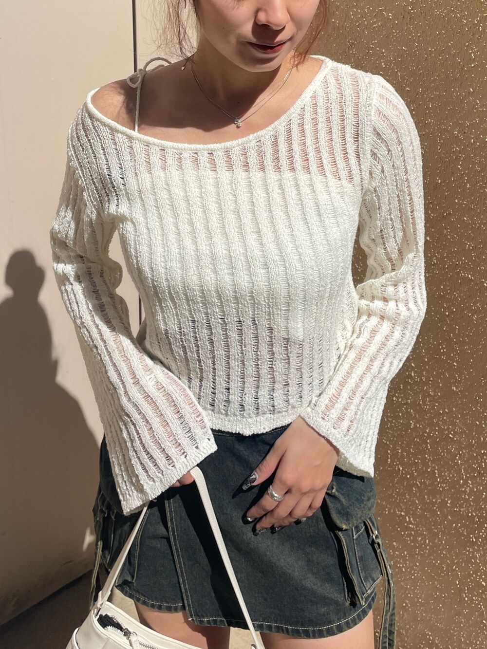 ホワイト系のニット/セーター、ブルー系のその他パンツ、ホワイト系のハンドバッグを着用したレディースの春コーディネートの4枚目の写真