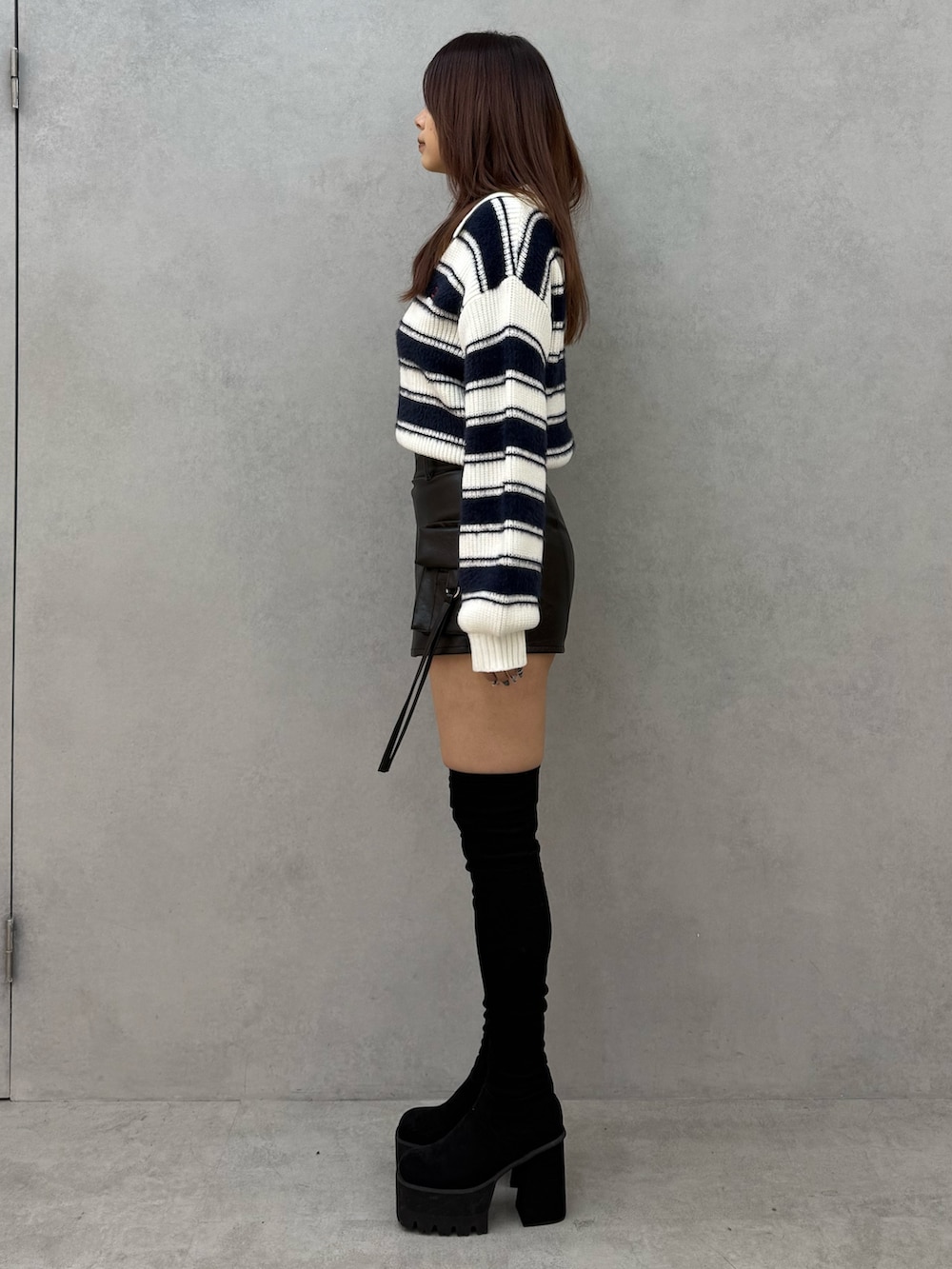 ブルー系のニット/セーター、ブラック系のその他パンツ、ブラック系のブーツを着用したレディースの冬コーディネートの2枚目の写真