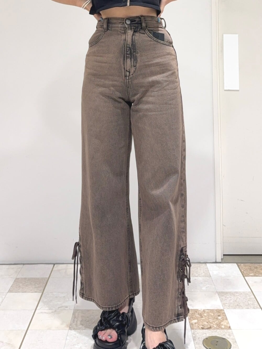 ブラック系のカーディガン/ボレロ、ブラウン系のデニムパンツ、ブラック系のサンダルを着用したレディースの夏コーディネートの5枚目の写真