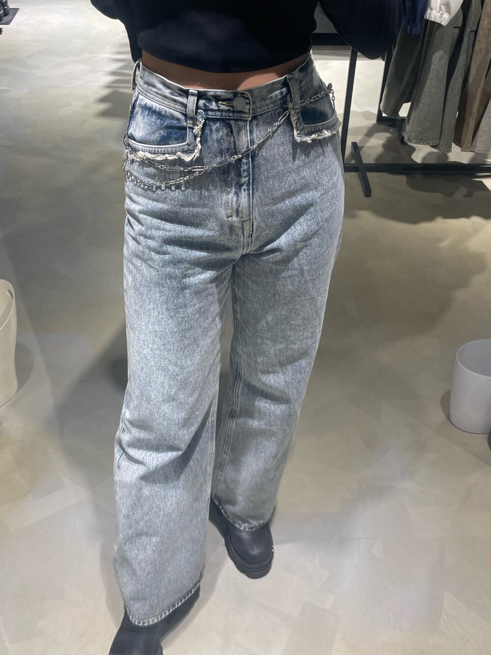 ブラック系のTシャツ/カットソー、ブルー系のデニムパンツ、ブラック系のブーツを着用したレディースの春コーディネートの6枚目の写真