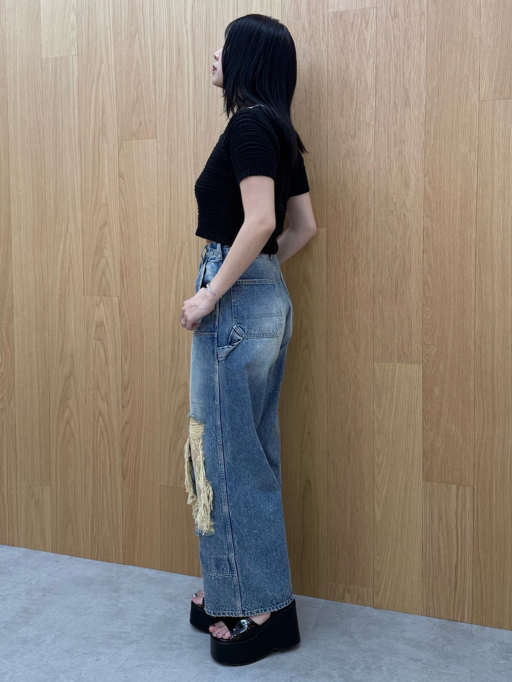 ブラック系のサンダル、ブルー系のデニムパンツ、ブラック系のニット/セーターを着用したレディースの春コーディネートの2枚目の写真