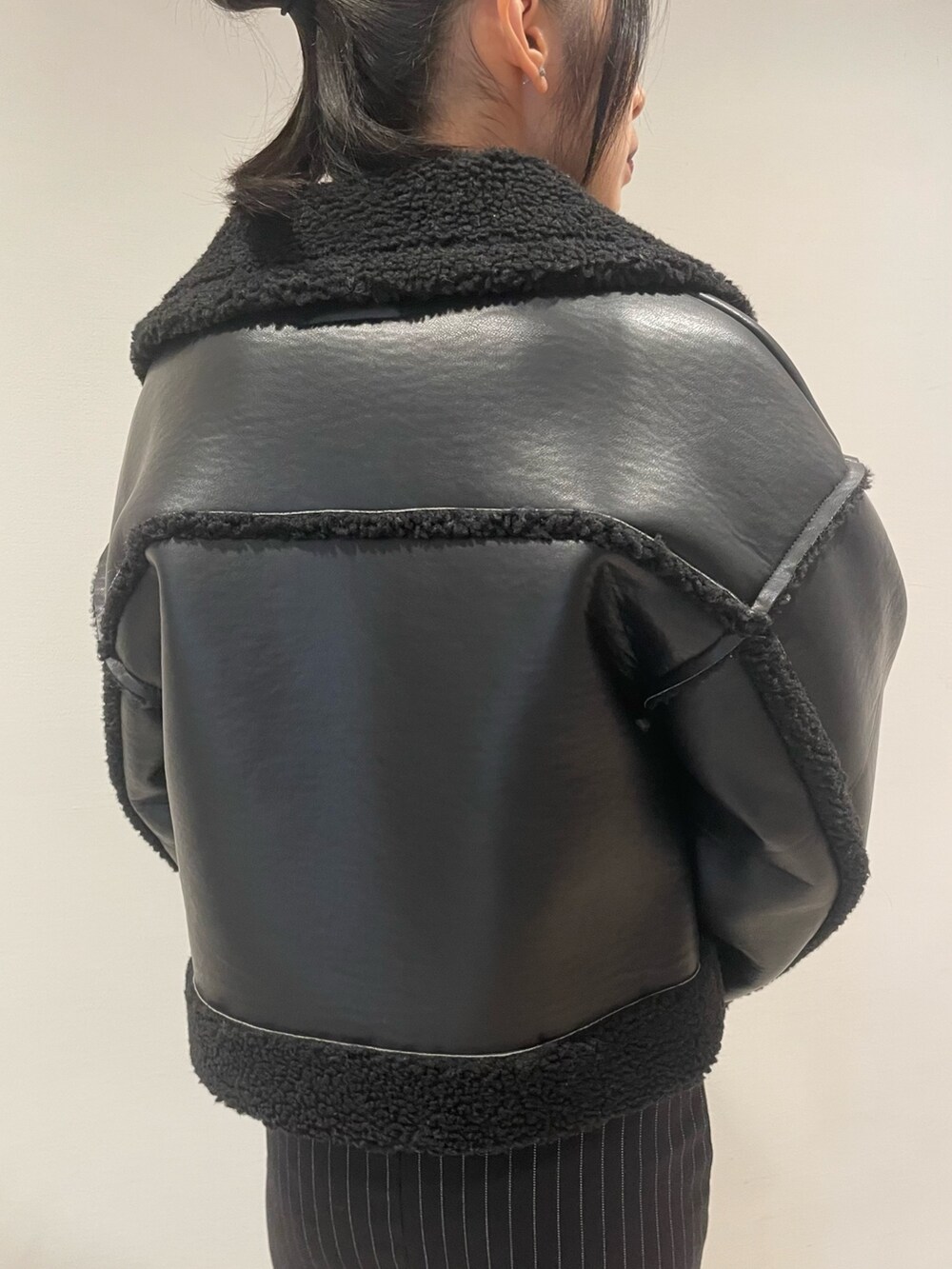 レッド系のスウェット、ブラック系のブルゾン、ブラック系のハンドバッグを着用したレディースの冬コーディネートの6枚目の写真