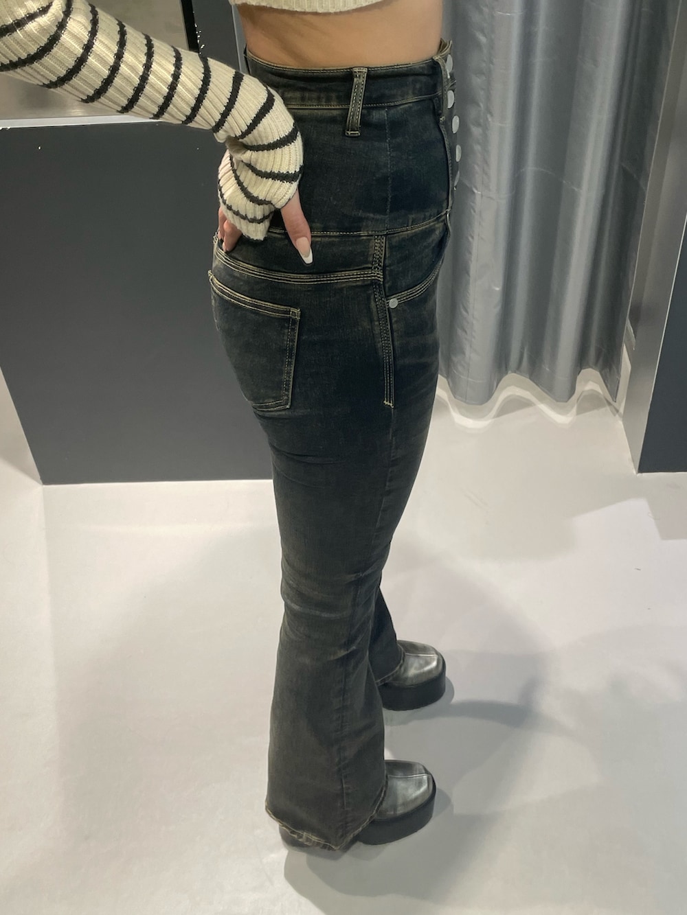 ホワイト系のニット/セーター、グレー系のブルゾン、ブルー系のデニムパンツを着用したレディースの秋コーディネートの9枚目の写真