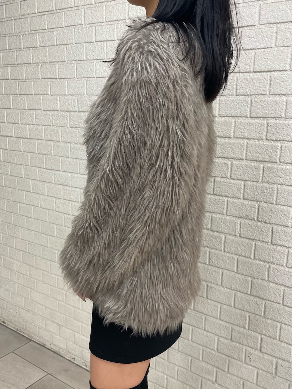 グレー系のカーディガン/ボレロ、ホワイト系のTシャツ/カットソー、ブラック系のスカートを着用したレディースの秋コーディネートの5枚目の写真