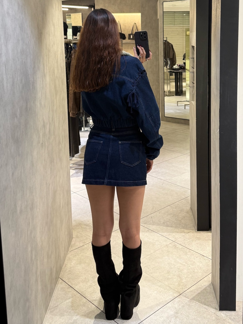 ブルー系のブルゾン、ブラック系のニット/セーター、ブルー系のスカートを着用したレディースの秋コーディネートの3枚目の写真