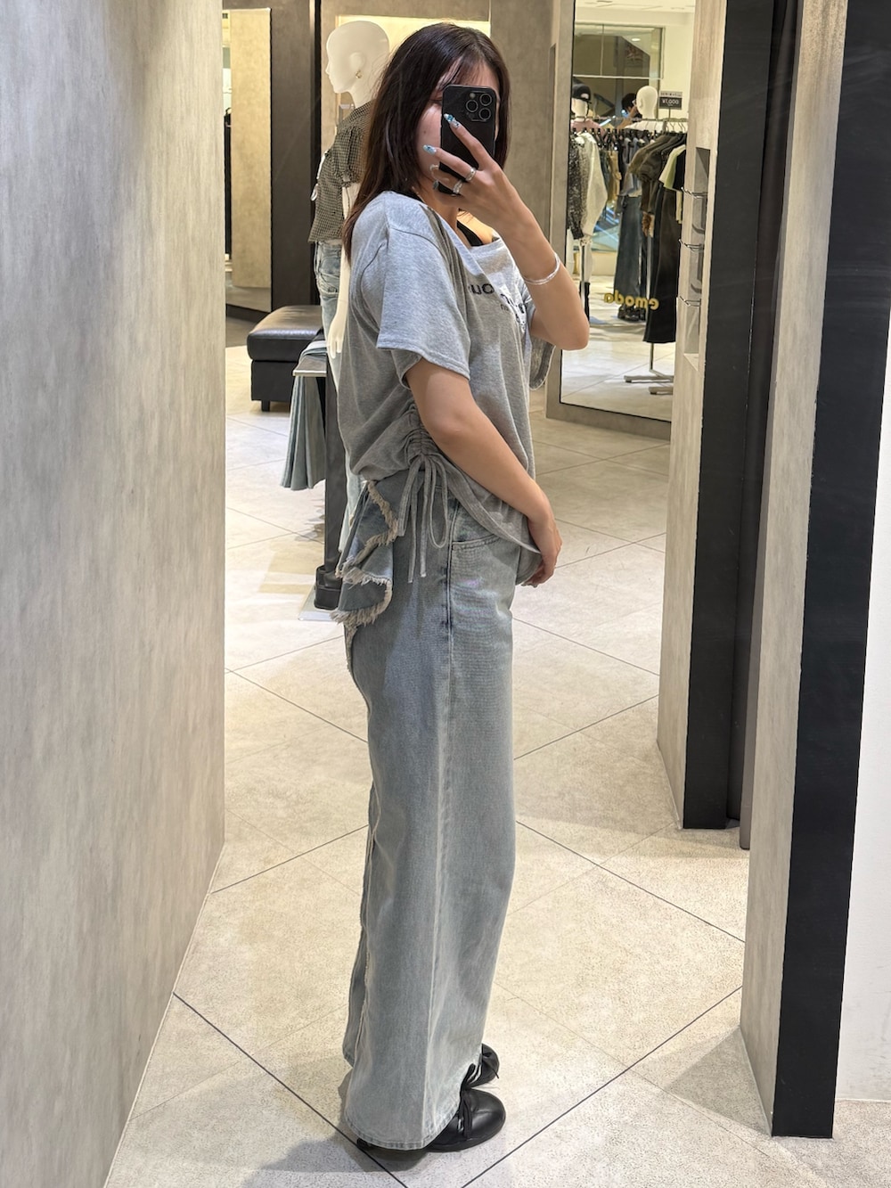 グレー系のTシャツ/カットソー、ブルー系のデニムパンツ、ブラック系のスニーカーを着用したレディースの春コーディネートの2枚目の写真