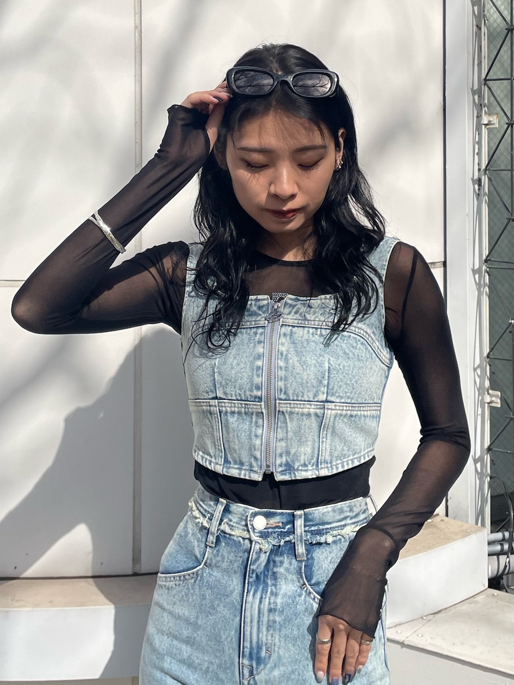 ブラック系のTシャツ/カットソー、ブルー系のキャミソール、ブルー系のデニムパンツを着用したレディースの春コーディネートの4枚目の写真