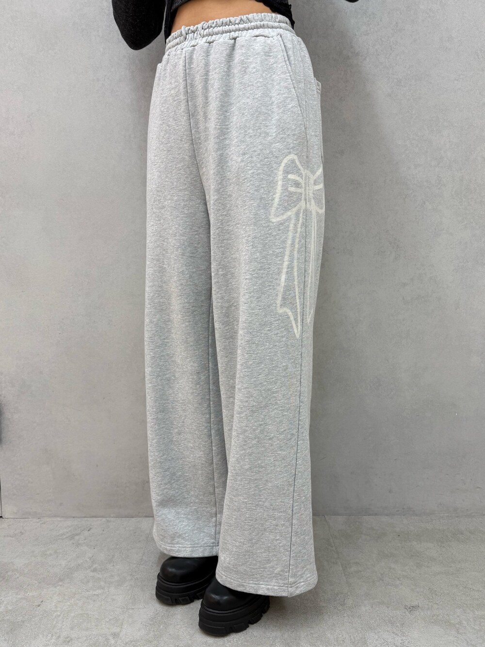 ブラック系のブルゾン、ブラック系のニット/セーター、グレー系のスウェットパンツを着用したレディースの冬コーディネートの7枚目の写真