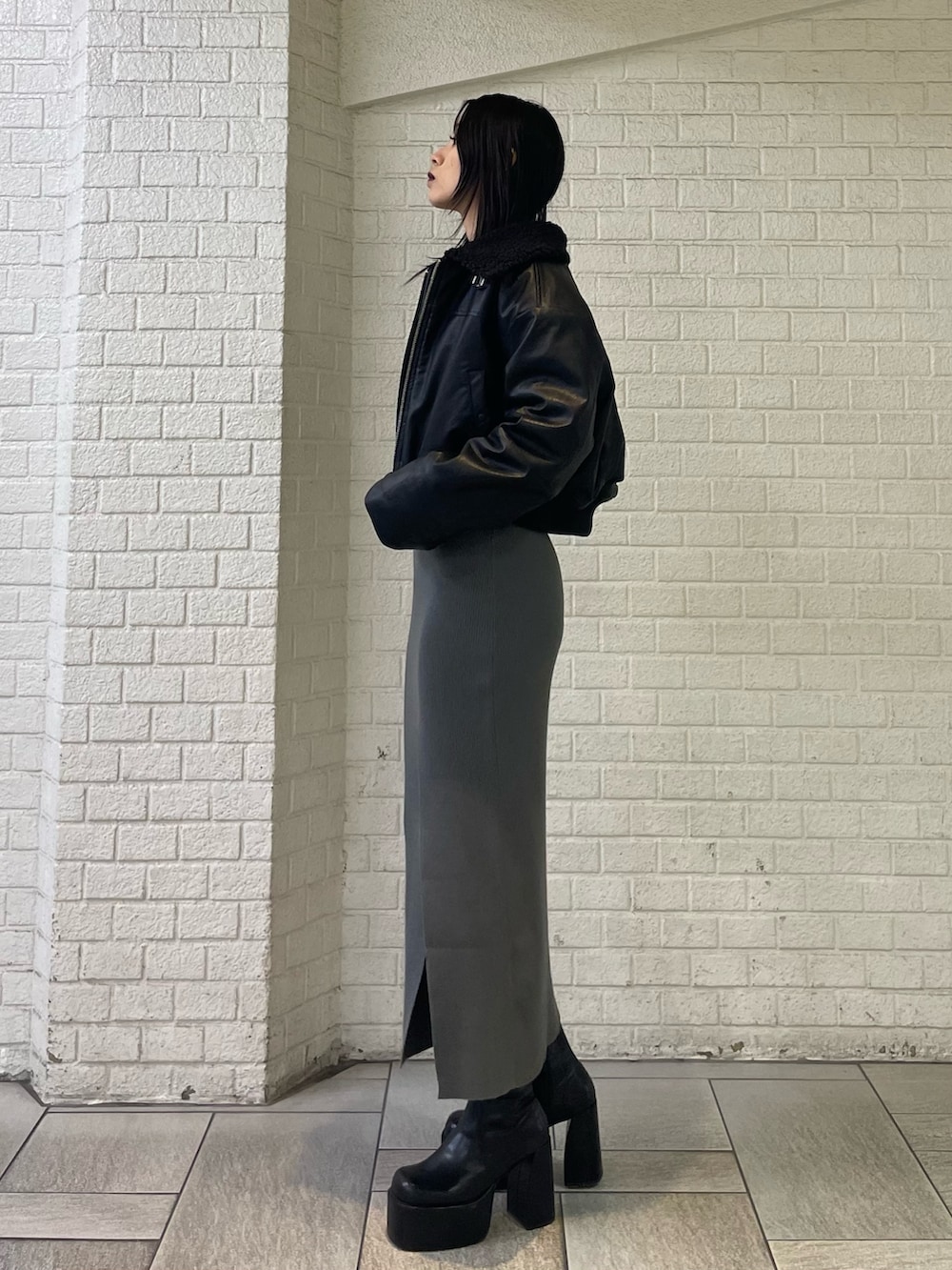 ブラック系のブルゾン、グレー系のワンピース、ブラック系のブーツを着用したレディースの秋コーディネートの2枚目の写真