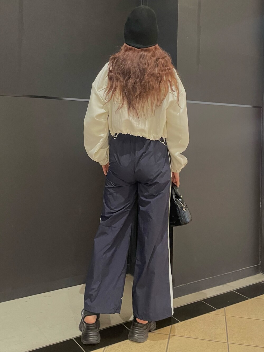 ブラック系のTシャツ/カットソー、ホワイト系のブルゾン、ブルー系のその他パンツを着用したレディースの春コーディネートの3枚目の写真