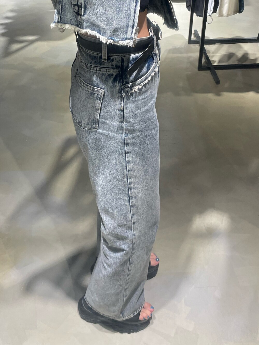 ブラック系のTシャツ/カットソー、ブルー系のベスト、ブルー系のデニムパンツを着用したレディースの春コーディネートの7枚目の写真