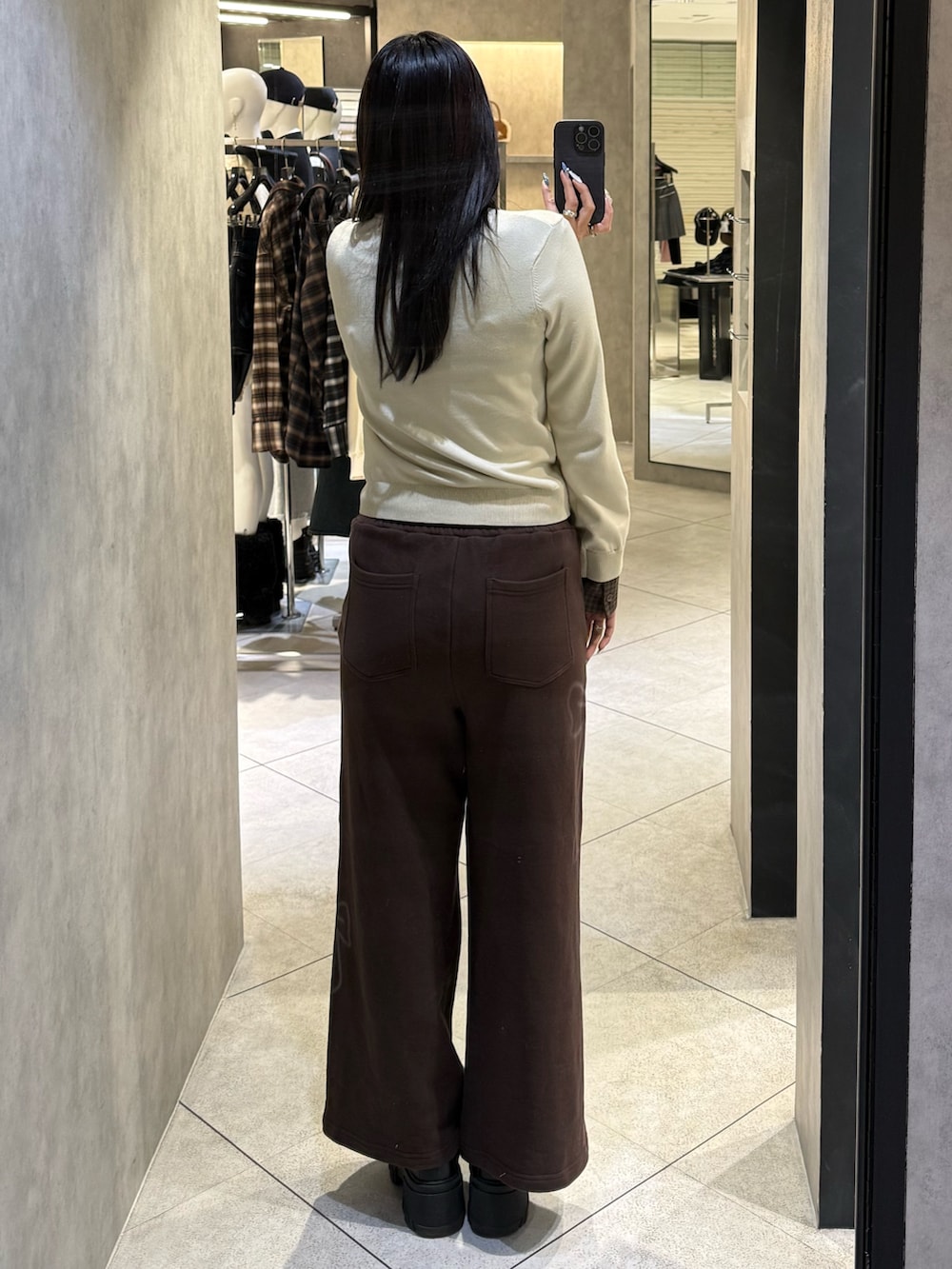 ベージュ系のシャツ/ブラウス、ブラウン系のスウェットパンツ、ブラック系のブーツを着用したレディースの冬コーディネートの3枚目の写真