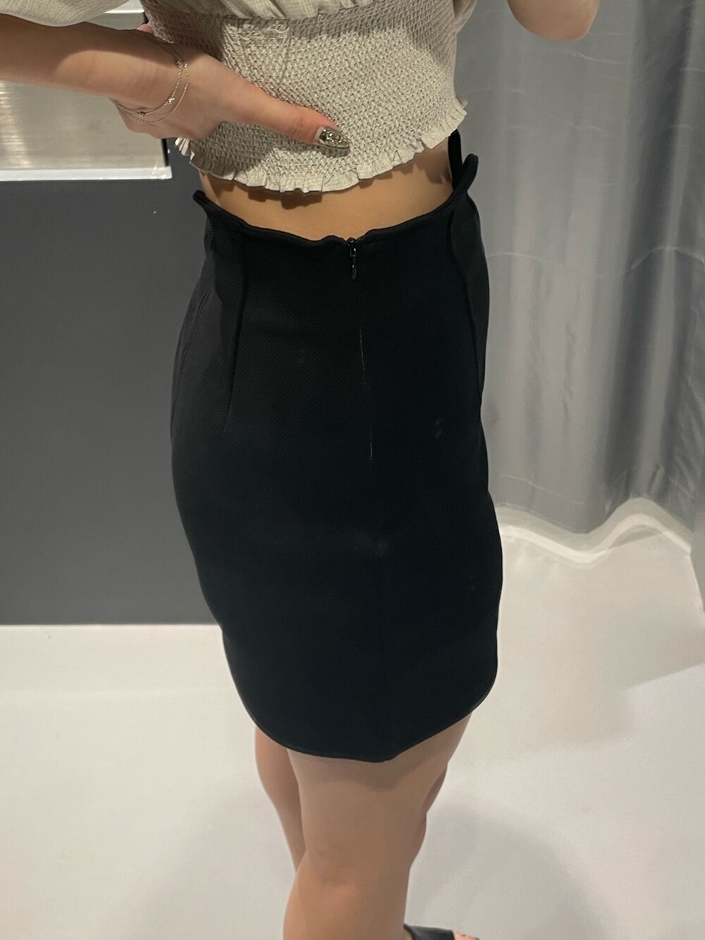 ベージュ系のTシャツ/カットソー、ブラック系のスカート、ブラック系のサンダルを着用したレディースの夏コーディネートの8枚目の写真