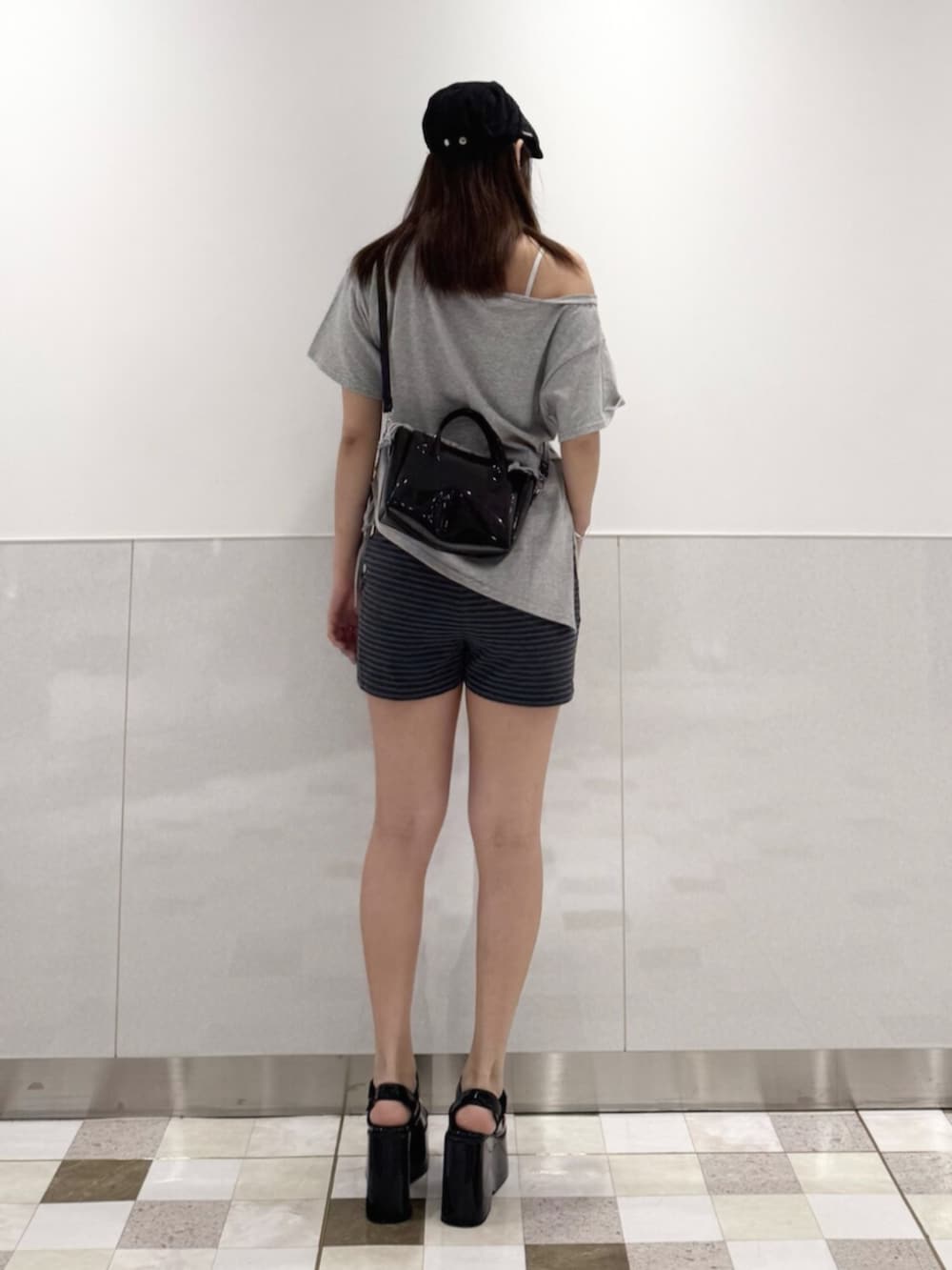 グレー系のTシャツ/カットソー、ブラック系のサンダル、ブラック系のハンドバッグを着用したレディースの夏コーディネートの3枚目の写真