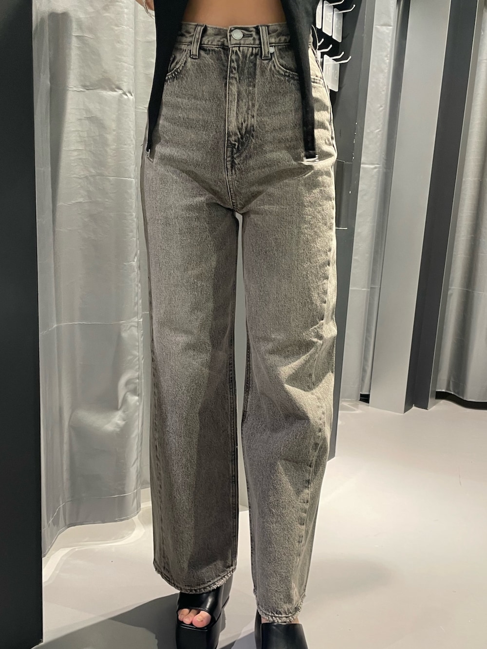 ブラック系のサンダル、ブラック系のTシャツ/カットソー、グレー系のデニムパンツを着用したレディースの春コーディネートの7枚目の写真