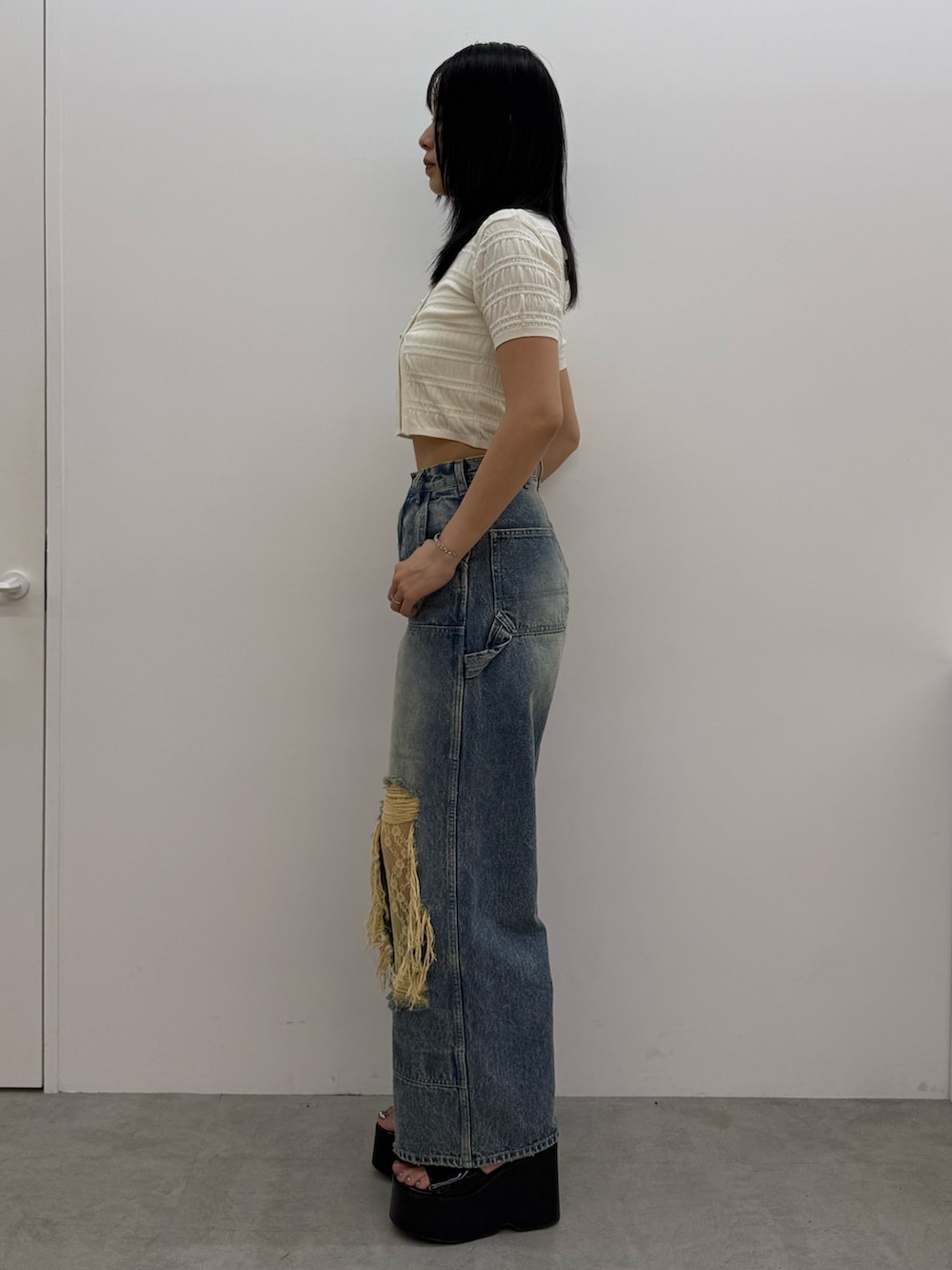 ブラック系のサンダル、ブルー系のデニムパンツ、ホワイト系のニット/セーターを着用したレディースの春コーディネートの2枚目の写真