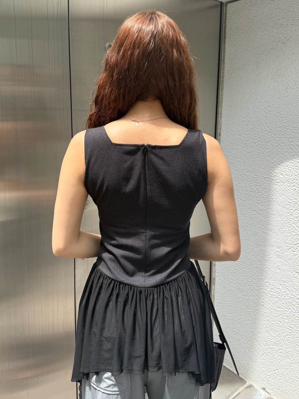 ブラック系のTシャツ/カットソー、ブラック系のハンドバッグ、グレー系のその他パンツを着用したレディースの夏コーディネートの6枚目の写真
