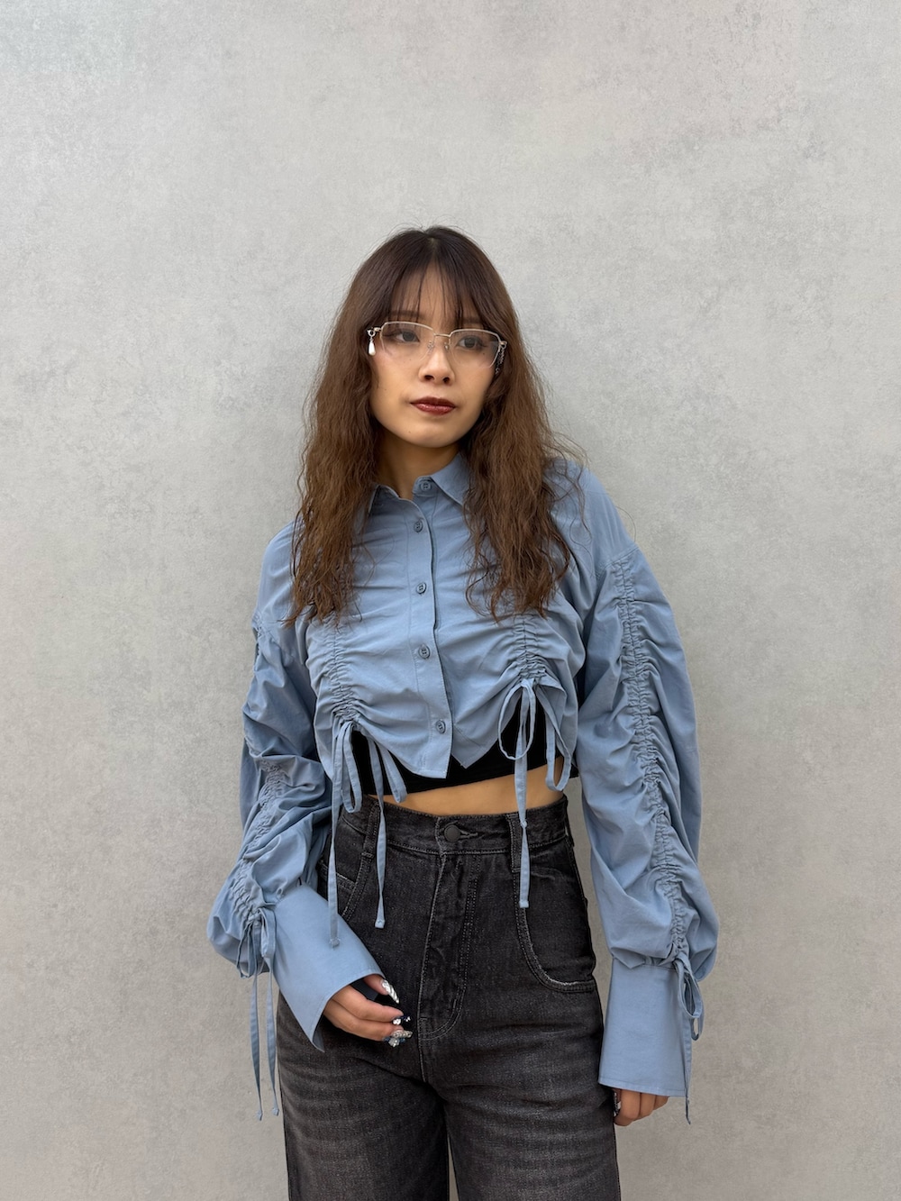 ブルー系のシャツ/ブラウス、ブラック系のキャミソール、ブラック系のデニムパンツを着用したレディースの秋コーディネートの4枚目の写真