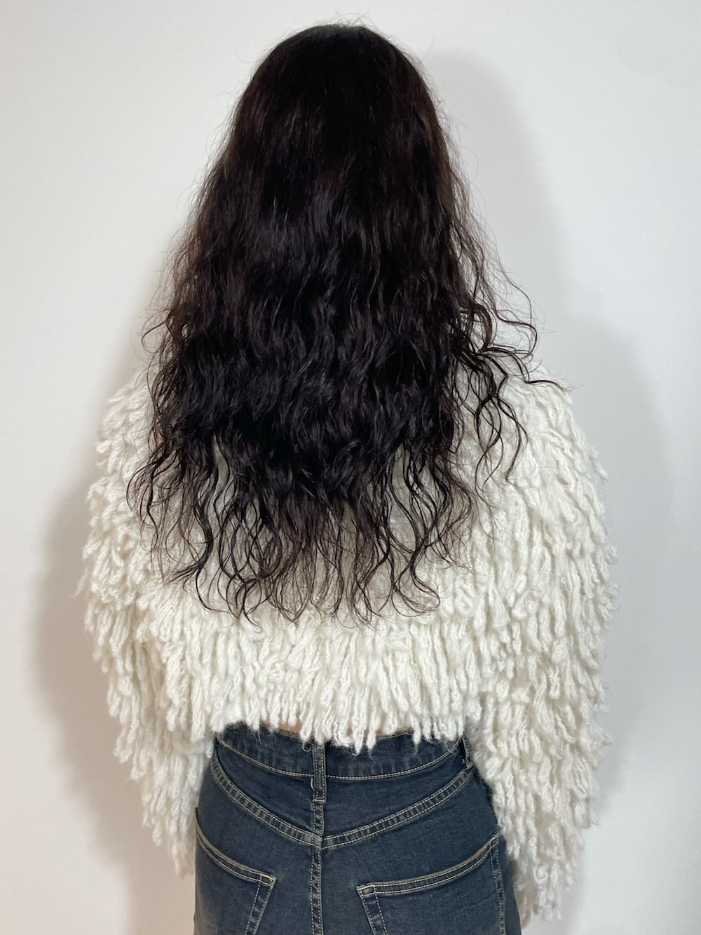 ホワイト系のニット/セーター、ブラック系のスカート、ブラック系のブーツを着用したレディースの秋コーディネートの6枚目の写真