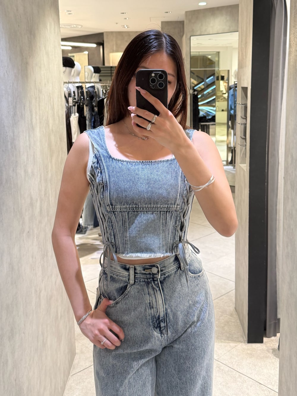 ホワイト系のニット/セーター、ブルー系のタンクトップ、ブルー系のデニムパンツを着用したレディースの春コーディネートの4枚目の写真