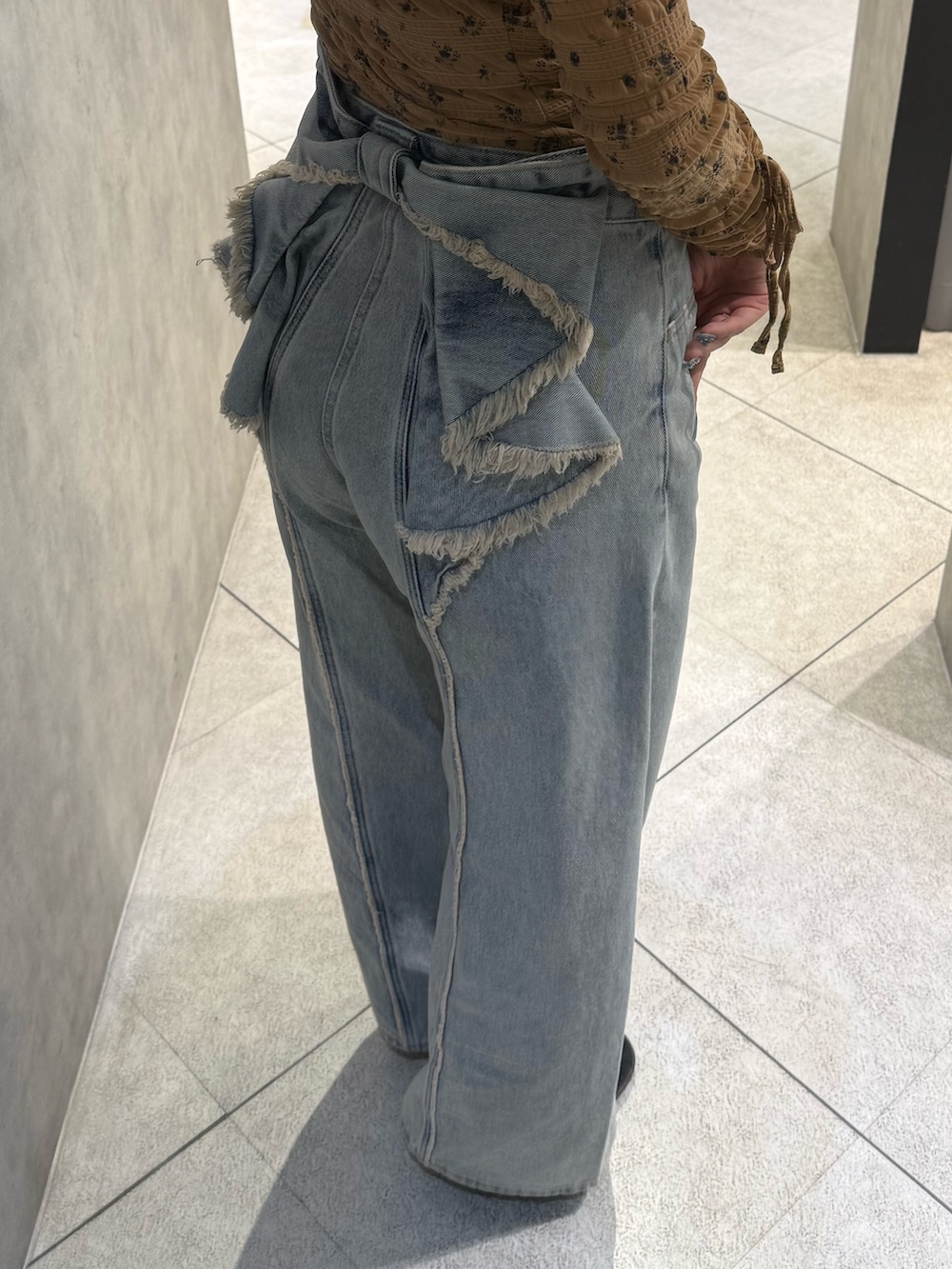 ブラック系のTシャツ/カットソー、ブルー系のデニムパンツ、ブラック系のスニーカーを着用したレディースの春コーディネートの5枚目の写真