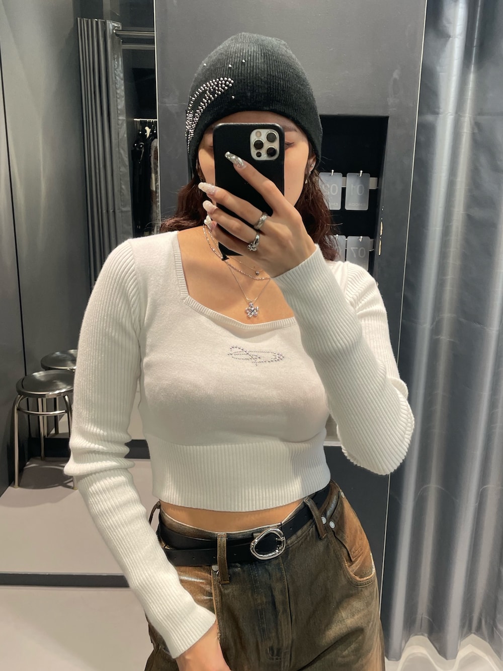 ホワイト系のニット/セーター、ブラウン系のデニムパンツ、ブラック系のブーツを着用したレディースの冬コーディネートの6枚目の写真