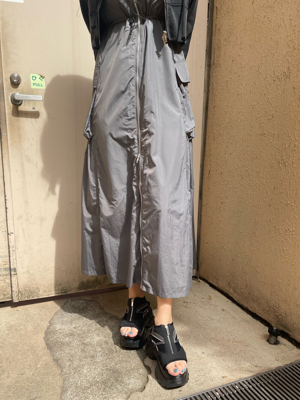 ブラック系のTシャツ/カットソー、グレー系のワンピース、ブラック系のサンダルを着用したレディースの春コーディネートの7枚目の写真