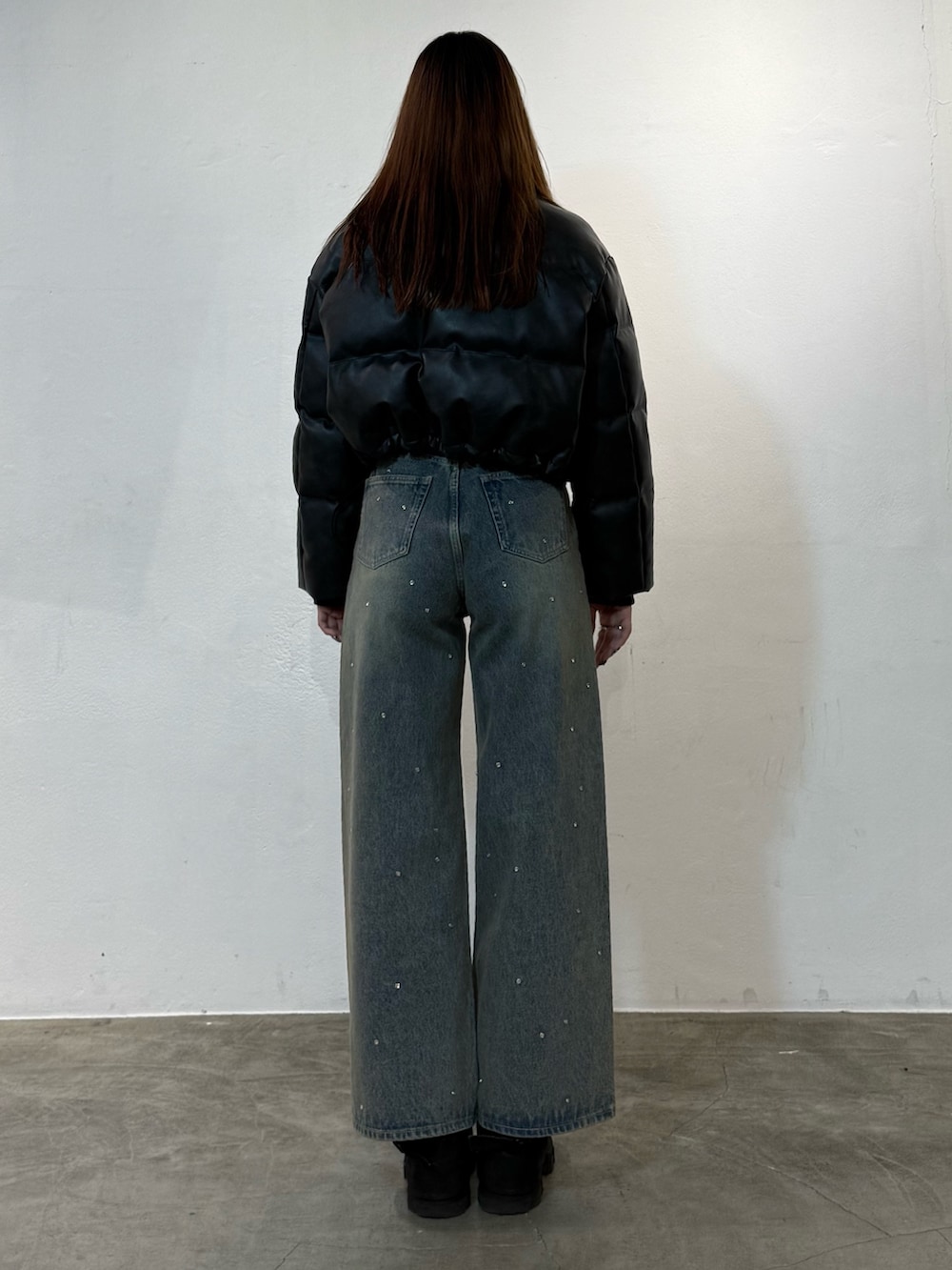 ブラック系のダウンジャケット/コート、ブルー系のデニムパンツ、ブラック系のブーツを着用したレディースの冬コーディネートの3枚目の写真