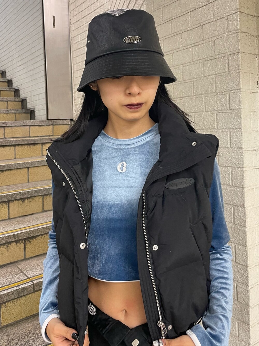 ブラック系のダウンベスト、ブルー系のTシャツ/カットソー、ブラック系のその他パンツを着用したレディースの秋コーディネートの4枚目の写真