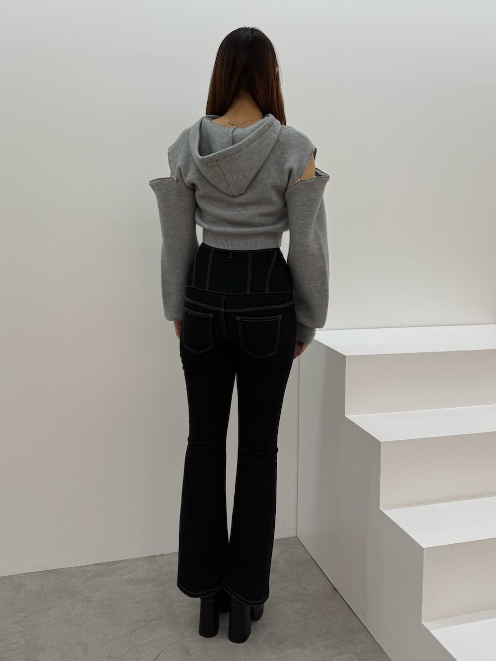 グレー系のパーカー、ブラック系のデニムパンツ、ブラック系のサンダルを着用したレディースの冬コーディネートの3枚目の写真