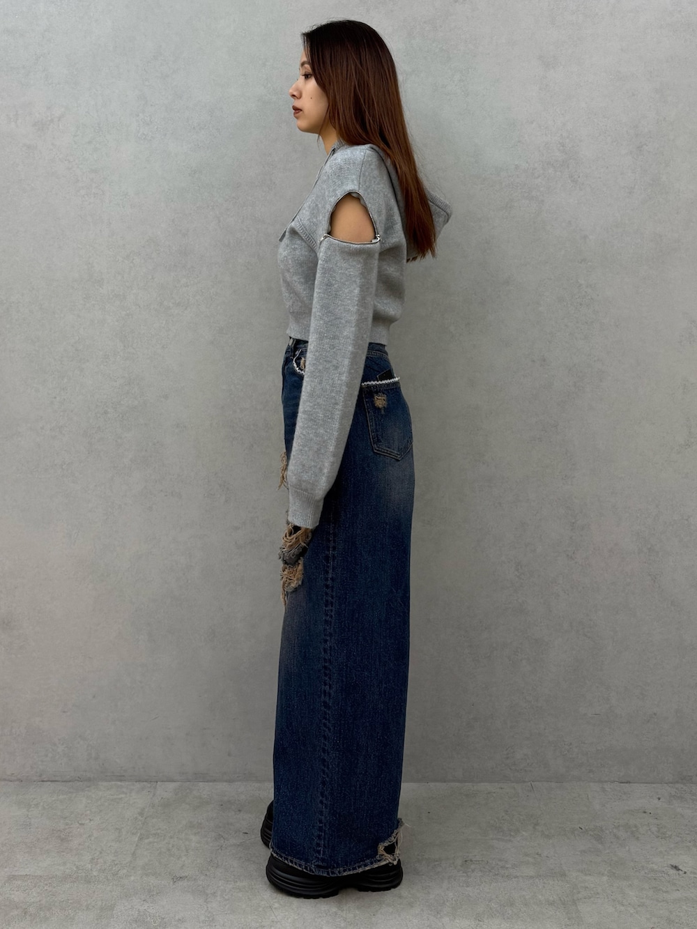 グレー系のパーカー、ブルー系のデニムパンツ、ブラック系のローファーを着用したレディースの冬コーディネートの2枚目の写真