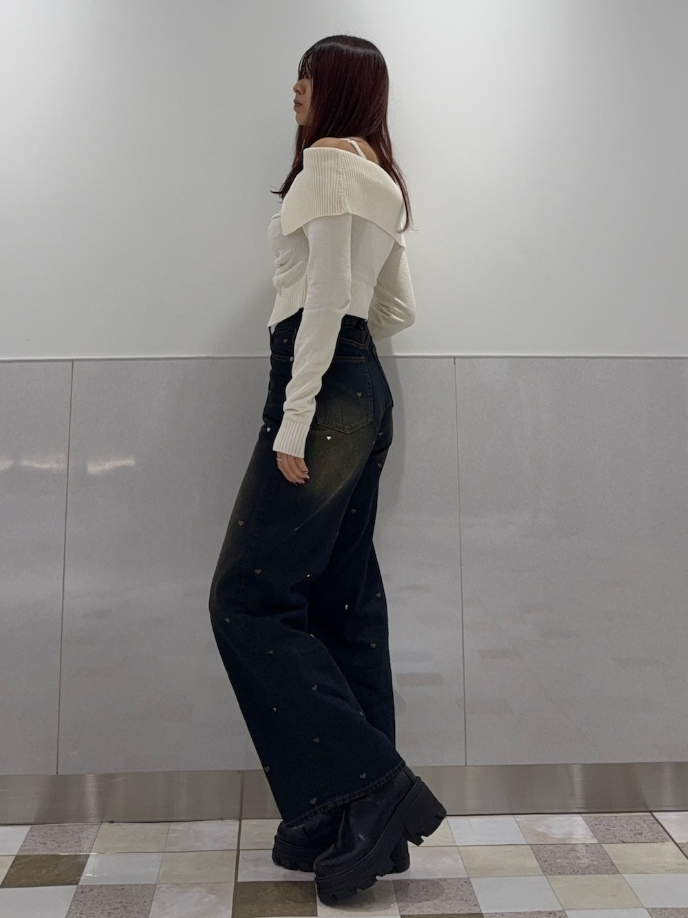 ホワイト系のニット/セーター、ブルー系のデニムパンツ、ブラック系のブーツを着用したレディースの秋コーディネートの2枚目の写真