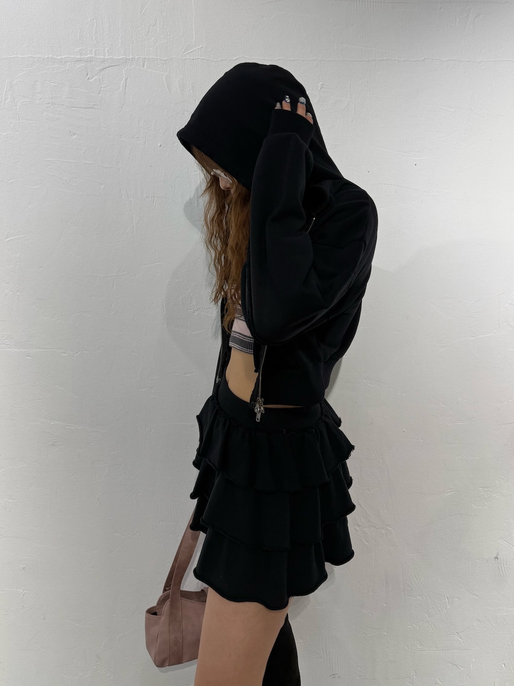 ピンク系のニット/セーター、ブラック系のパーカー、ブラック系のスカートを着用したレディースの秋コーディネートの5枚目の写真