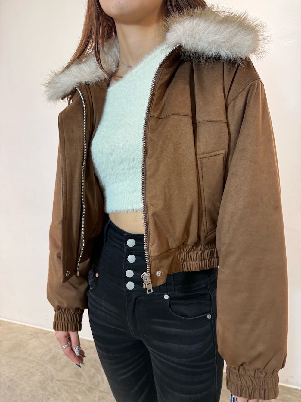 ホワイト系のニット/セーター、ベージュ系のブルゾン、ブラック系のデニムパンツを着用したレディースの冬コーディネートの4枚目の写真