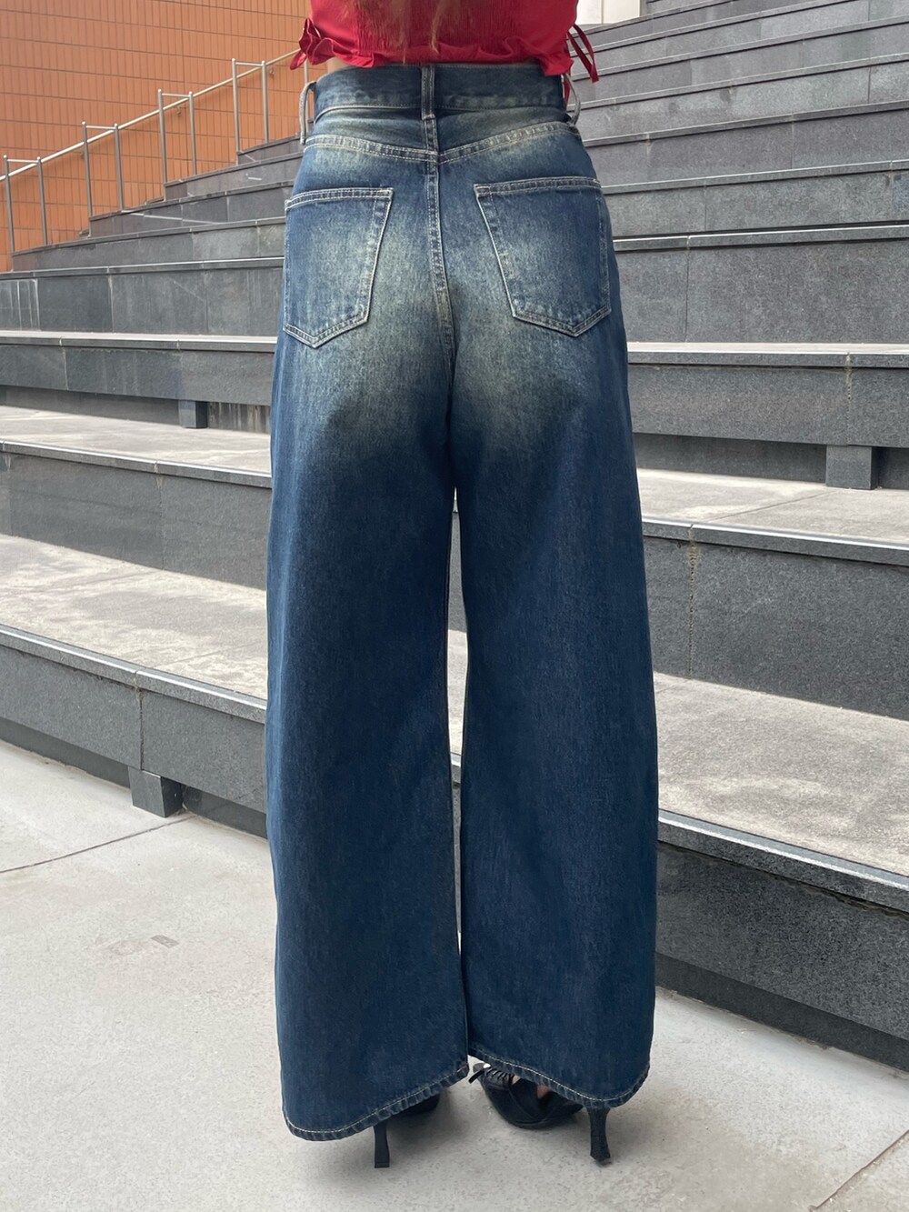 レッド系のTシャツ/カットソー、ブルー系のデニムパンツ、ブラック系のハンドバッグを着用したレディースの春コーディネートの9枚目の写真