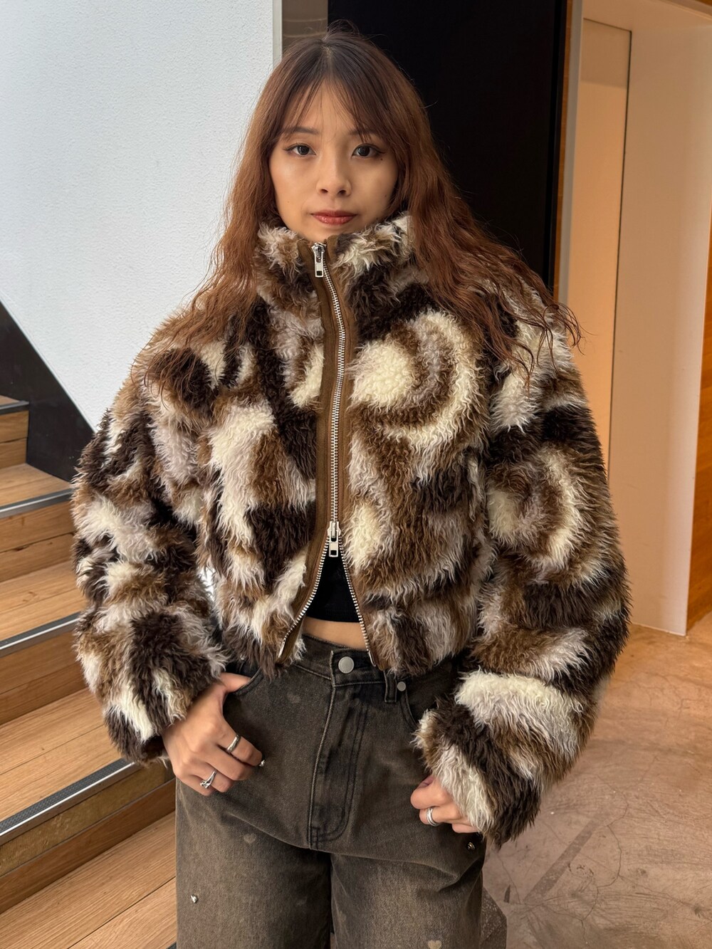 ブラウン系のブルゾン、ブラック系のニット/セーター、ブラウン系のデニムパンツを着用したレディースの秋コーディネートの4枚目の写真