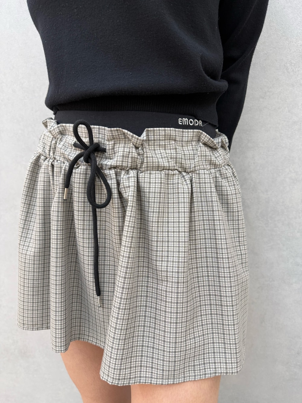 ブラック系のTシャツ/カットソー、ブラック系のスカート、ブラック系のブーツを着用したレディースの冬コーディネートの6枚目の写真